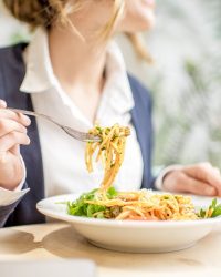 Businesswoman eating pasta at the restaurant